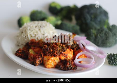 Tandoori Paneer Brokkoli. Quark-Würfel und Brokkoli-Röschen, mariniert mit Joghurt und Gewürzen und gebraten. Eine gesunde Beilage zusammen mit ric Stockfoto