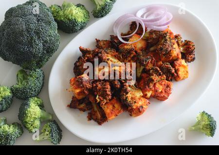 Tandoori Paneer Brokkoli. Quark-Würfel und Brokkoli-Röschen, mariniert mit Joghurt und Gewürzen und gebraten. Gesunde Vorspeise oder ein abendlicher Schnüpfer Stockfoto