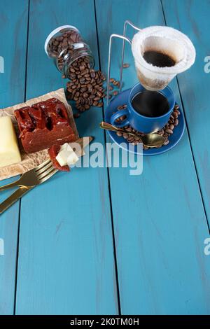 Goldene Gabel mit Stücken Guava süß mit Käse neben Messer, Bohnen und Tasse Coffee Vertical. Stockfoto