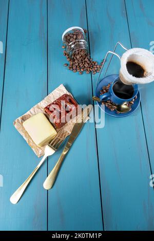 Guava süß mit Käse auf braunem Papier, umgeben von Besteck, Bohnen und einer Tasse Coffee Verticval. Stockfoto