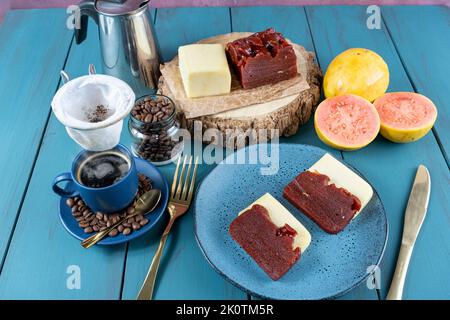 Guava süß mit Käse, umgeben von Tasse und Kaffeebohnen auf einem blauen Tisch Stockfoto