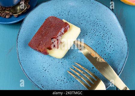 Nahaufnahme von süßen Guava-Scheiben mit Käse neben Besteck und Kaffeebohnen. Stockfoto