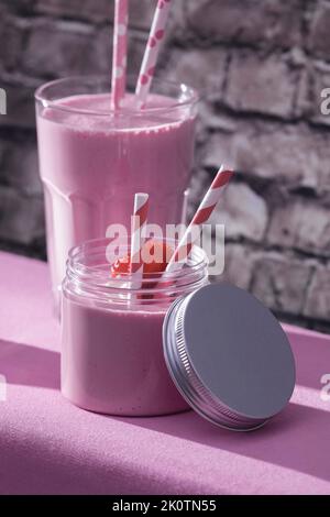 Verführerische Erdbeermilchshakes mit Erdbeer- und Papierstrohhalmen Stockfoto