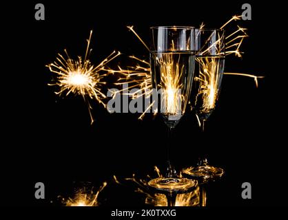 Zwei Gläser Champagner mit Glitzer im Hintergrund. Silvesterfeier. Stockfoto