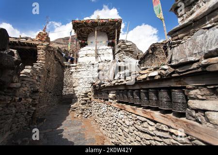 Stupa und Gebetsräder Wand in Manang villlage, eines der besten Dörfer in rund Annapurna Circuit Trekking Trail Route, Nepal Stockfoto