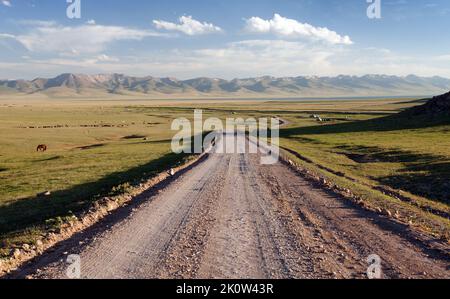 Unbefestigte Straße und Jurten in der Nähe von Son-Kul See und Tien shan Gebirge in Kirgisistan Stockfoto