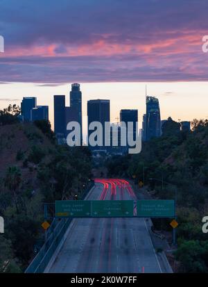 Leichte Wege auf der Autobahn 110, die bei Sonnenuntergang in die Innenstadt von Los Angeles führt Stockfoto