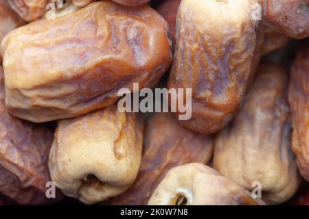 Datteln in einer Holzschale auf weißem Hintergrund. Getrocknete Datteln Früchte. Stockfoto