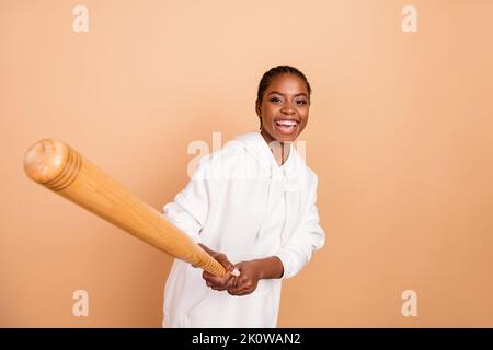 Portrait der fröhlichen positive Dame halten Baseballschläger haben gute Laune isoliert auf beige Farbe Hintergrund Stockfoto