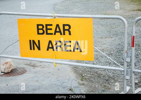 Gelbes Warnschild Bär in der Gegend informiert über Wildtieraktivitäten in der Gegend in der Nähe von Trail im Provincial Park Stockfoto