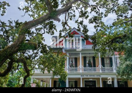 NEW ORLEANS, LA, USA - 7. SEPTEMBER 2022: Obere Etage des Parkview Historic Hotel und eine weitläufige, lebende Eiche an der St. Charles Avenue Stockfoto