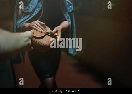 Dieb schnappt der Frau auf der Nachtstraße einen Beutel. Stockfoto