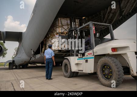 Chaklala, Pakistan. 09. September 2022. Ein pakistanischer Flieger beobachtet, wie US-Militärpersonal, das dem Central Command zugewiesen ist, Hilfsgüter von einem USAF C-130-Frachtflugzeug zur Unterstützung einer humanitären Mission der USAID auf dem pakistanischen Luftwaffenstützpunkt nur Khan, 9. September 2022 in Chaklala, Provinz Punjab, Pakistan, entladen kann. Die Luftwaffe begann mit dem Transport von 630 Tonnen Hilfsgütern, nachdem massive Überschwemmungen das Land verwüstet hatten. Kredit: SSGT. Charles Fultz/US Air Force Photo/Alamy Live News Stockfoto