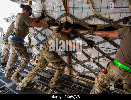 Abu Dhabi, Vereinigte Arabische Emirate. 11. September 2022. US-Militärangehöriger, die dem Central Command zugewiesen sind, laden Hilfsgüter in ein Frachtflugzeug der USAF C-130 zur Unterstützung einer humanitären Mission der USAID für Pakistan auf dem Luftwaffenstützpunkt Al Dhafra am 11. September 2022 in Abu Dhabi, Vereinigte Arabische Emirate. Die Luftwaffe begann mit dem Transport von 630 Tonnen Hilfsgütern, nachdem massive Überschwemmungen das Land verwüstet hatten. Kredit: TSgt. Isaac Garden/US Air Force Foto/Alamy Live News Stockfoto