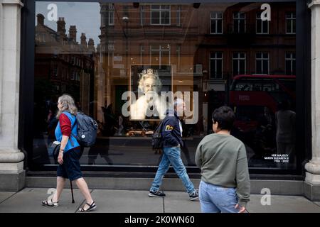 London, Großbritannien. 13. September 2022. Die Leute halten an und schauen sich das Porträt von Königin Elizabeth II. An, das auf dem Schaufenster auf Selfridges zu sehen ist. Geschäfte zollen Queen Elizabeth II. In der Hauptstraße im Zentrum Londons Tribut. (Bild: © Hesther Ng/SOPA Images via ZUMA Press Wire) Stockfoto