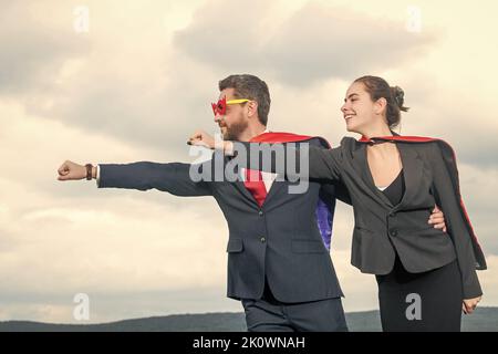 Ehrgeiziges Business-Paar im Superheldenanzug mit Sternenhimmel-Hintergrund Stockfoto