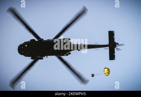 Eine US-Army National Guard UH-60 Black Hawk Crew legt am 8. September 2022 während einer Lufttropfen- und Schleuderbelastung im Rahmen eines U.S. Pathfinder Course im Camp Dodge in Johnston, Iowa, eine Schachtel mit verzehrfertigen Mahlzeiten ab. Fast 30 Soldaten absolvierten den Kurs, der von einem mobilen Trainingsteam im Warrior Training Center der Army National Guard in Fort Benning, Georgia, unterrichtet wurde. Jeder Soldat wurde mit einem MRE-Paket beauftragt und mit der Koordination eines Luftabfalls an einem bestimmten Ort beauftragt. Army Pathfinders sind geschult, um Navigationshilfe und Beratungsdienste für Militärflugzeuge in Gebieten Design zu bieten Stockfoto