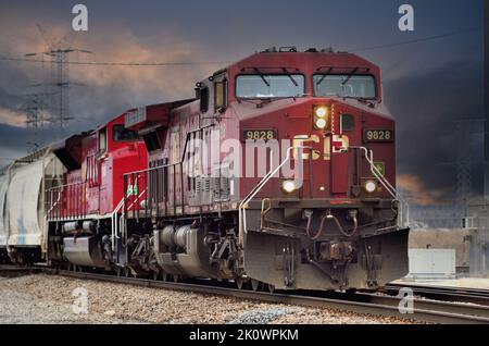 Elgin, Illinois, USA. Zwei Lokomotiven der Canadian Pacific Railway führen einen Güterzug östlich durch die Vororte von Chicago. Stockfoto