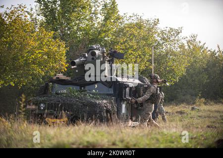 503. Fallschirmjäger der US-Armee, der dem Bataillon 1. zugewiesen wurde, wirft eine Granate, um die abgesetzten Truppen der gegnerischen Streitkräfte zu stoppen, während ein Revolverschütze den Rückschlagbereich freilegt, bevor er einen BGM-71 Tube-abfeuert, der optisch verfolgt, Im Rahmen der Übung Sabre Junction 22, 13. September 2022, wurde die Panzerabwehrrakete auf das Fahrzeug der gegnerischen Streitkräfte im Joint Multinal Readiness Center in Hohenfels, Deutschland, mit einer Drahtseitenführung (TOW) gesteuert. Sabre Junction 22 ist eine multinationale Rotationsübung, mit der die Bereitschaft der Luftbrigade 173. der US-Armee zur Ausführung einer einheitlichen Landoperation bewertet werden soll Stockfoto