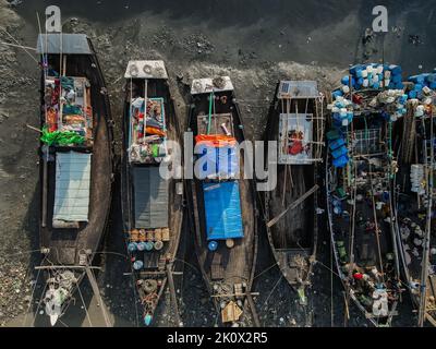 Fischer schlafen auf Fischerbooten. Sie fangen die ganze Nacht in der Tiefsee Fisch und kommen zum Chittagong-Fischghat am Flussufer und schlafen unter freiem Himmel im Boot. Chittagong und Cox's Bazar ist das wichtigste Zentrum der Seefischerei in Bangladesch. Mehr als 40.000 Familien beschäftigten sich mit der Seefischerei. Chittagong, Bangladesch. Stockfoto