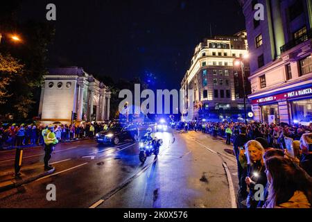 London, Großbritannien. 13. September 2022. Tausende von Menschen versammeln sich auf dem Weg des staatlichen Leichenschauens von Königin Elizabeth II. Im Regen, um sich von ihrer Majestät endgültig zu verabschieden. Der Staatswagen von Königin Elizabeth II. Kam heute Abend von Edinburgh nach London in Northolt an und fuhr durch Central London, einschließlich Marble Arch, zum Buckingham Palace. Der Sarg Ihrer Majestät wird morgen vom Buckingham Palace zum Palace of Westminister übersiedeln, um dort bis zum nächsten Montagmorgen zu liegen. Kredit: SOPA Images Limited/Alamy Live Nachrichten Stockfoto