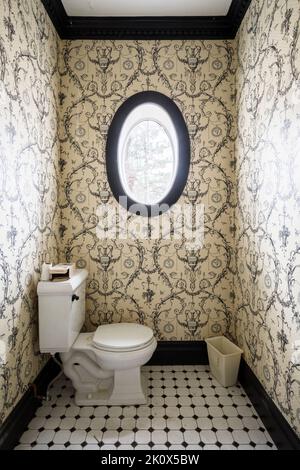 Ein kleines Badezimmer in einem Haus mit einem ovalen Fenster. Dieses Haus wurde seitdem abgerissen. Stockfoto