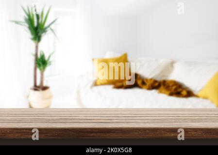 Holztisch in gemütlicher, moderner Wohneinrichtung. Verwischen Sie den Hintergrund des Wohnzimmers und das Modell mit Tischschreibtisch-Hintergrund. Layout der Produktanzeige. Stockfoto
