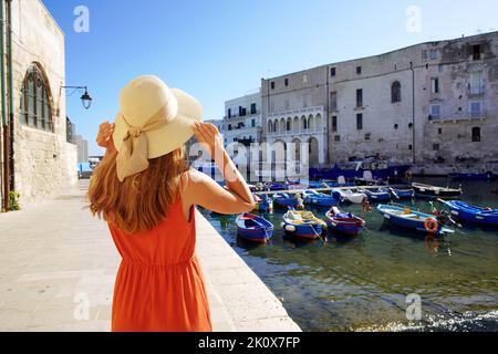 Tourismus in Apulien, Italien. Rückansicht der schönen Mode Mädchen genießen Blick auf Monopoli alten Hafen in Apulien, Italien. Urlaub Europe im Sommer. Stockfoto