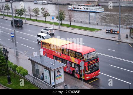 Leerer Touristenbus ohne Reisende in Moskau, Russland. Doppeldecker-roter Bus mit leeren Sitzen ohne Touristen. Chulpan Khamatova auf einer Werbeba
