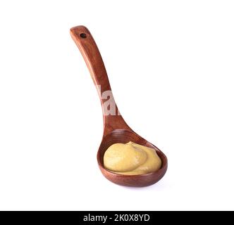 Ein isolierter Schuss eines Holzlöffels voller Dijon-Senf auf weißem Hintergrund Stockfoto