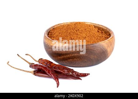 Ein isolierter Schuss roten gemahlenen Pfeffers in einer Holzschüssel und getrocknete Chilischoten auf weißem Hintergrund Stockfoto