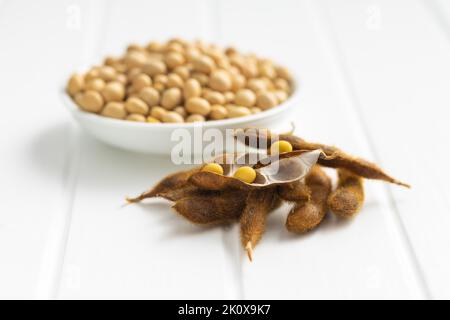 Sojabohnen. Getrocknete Sojabohnenschote auf dem weißen Tisch. Stockfoto