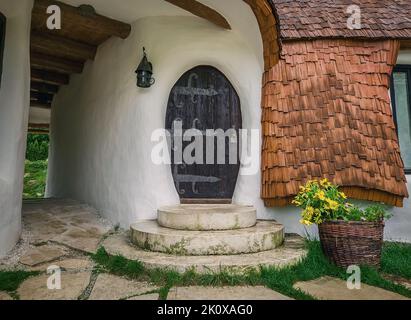 Das Clay Castle aus dem Tal der Feen, ein touristischer Komplex in Siebenbürgen, Rumänien. Nahaufnahme Blick auf eine kleine Eingangstür, Fantasy hobbit House f Stockfoto