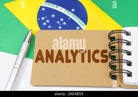 Konzept der nationalen Wirtschaft. Auf der Flagge Brasiliens liegt ein Notizbuch mit der Aufschrift - Analytics Stockfoto