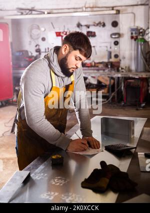Junger Mann Ingenieur Berechnung Größe des Materials Stockfoto