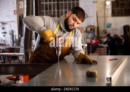 Handwerker, der mit manueller Elektrobohrmaschine arbeitet Stockfoto