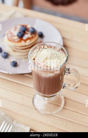 Dessert: Belgische Schokolade mit Eiscreme im Glas und traditionelle Pfannkuchen mit Sirup und Heidelbeere draußen. Leckeres Frühstück. Stockfoto