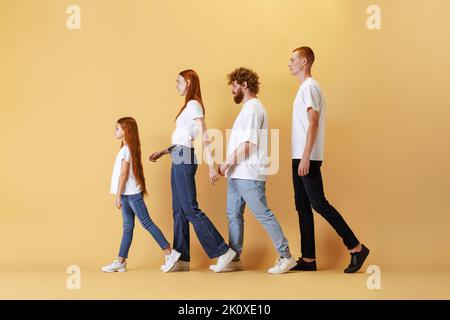 Vielfalt. Gruppe verschiedener Altersgruppen Rotschopf Menschen tragen weiße T-Shirts und Jeans posiert isoliert auf gelbem Hintergrund. Stockfoto