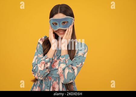 Teenager Mädchen in Samba Maske an Karneval isoliert auf gelbem Hintergrund. Kinder in Karnevalsmaske auf Geburtstagsparty, Feiertagskonzept. Stockfoto