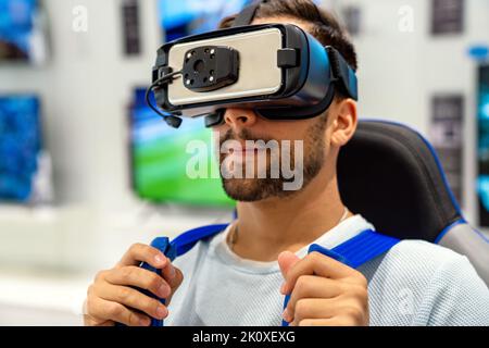 Glücklicher Mann mit VR-Brille und genießen Virtual-Reality-Spiel. Technologiesimulation People-Konzept Stockfoto