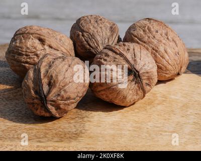 Gruppe von fünf Walnüssen auf einem Holzbrett Stockfoto