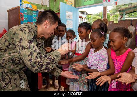 Honiara, Salomonen. 8. September 2022. HONIARA, Salomonen (Septembertemberember. 2, 2022) Hospital Corpsman 1. Class Neal Mendoza, aus Whidbey Island, Washington, beleuchtet die Hände lokaler Kinder, um während der Pacific Partnership 2022 angemessene Handwaschtechniken an der Naha SDA Primary School zu demonstrieren. Die Pacific Partnership ist die größte internationale Mission zur humanitären Hilfe und Katastrophenhilfe, die seit 17. Jahren im Indo-Pazifik-Raum durchgeführt wird. Pacific Partnership ist eine verbindende Mission, die dauerhafte Freundschaften und Zusammenarbeit untereinander fördert Stockfoto