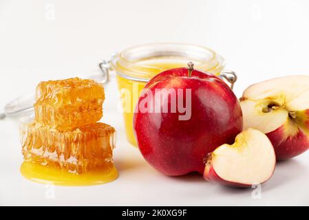 Einmachglas mit honigroten Äpfeln und Honigwabe auf weißem Hintergrund Stockfoto