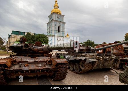 KIEW, UKRAINE 20. August 2022: Zerstörte militärische Ausrüstung der russischen Armee auf dem Mikhailowskaya-Platz vor dem Hintergrund der Kirchen in Stockfoto