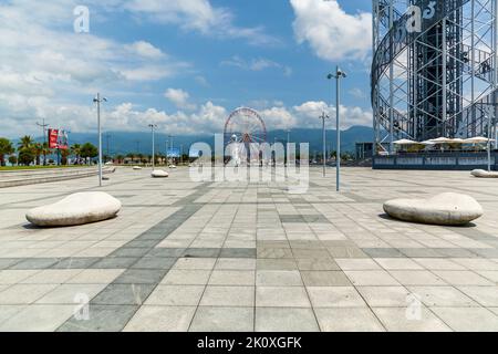 Batumi Georgia 25. Juni 2017: Riesenrad und alter Leuchtturm am Ufer in Batumi. Moderne Gebäude und touristische Entwicklung in Batumi, Georgien Stockfoto