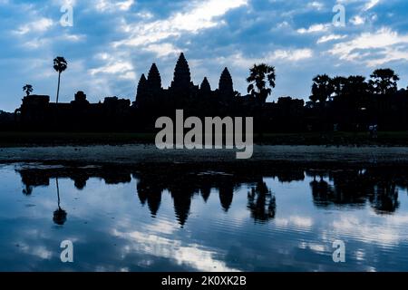 Kambodscha. Provinz Siem Reap. Eine Silhouette von Angkor Wat (Tempelstadt) und dessen Spiegelung im See am frühen Morgen. Ein buddhistischer und Tempelkomplex Stockfoto