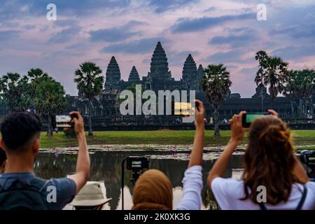 Kambodscha. Provinz Siem Reap. Eine Gruppe von Touristen fotografieren Angkor Wat (Tempelstadt) und seine Spiegelung im See, ein Buddhist und Tempel Stockfoto