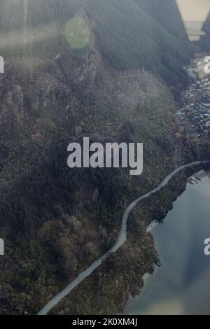 Eine Straße schlängelt sich um den Lake Wakatipu in der Nähe von Queenstown, Neuseeland Stockfoto