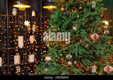 Weihnachtshintergrund, Weihnachtsbaum mit festlichen Kugeln, Spielzeug und magische Lichter geschmückt, vor dem Hintergrund der verschwommenen Bokeh Lichter und Loft-Stil p Stockfoto