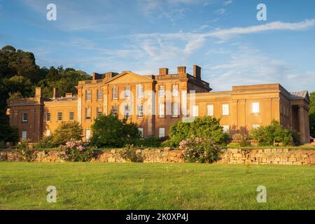 Himley Hall and Park in Staffordshire, Großbritannien, reflektiert das letzte Licht des Tages, das auf das Gebäude scheint. Stockfoto